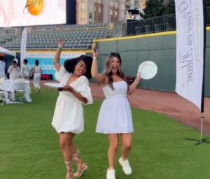 Diner En Blanc graphic showing two women dancing and posing for camera.