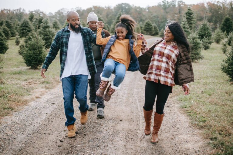 Family holding hands at Christmas Tree farm 768x512