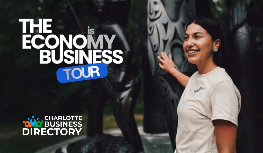 Woman standing beside sculpture and The Economy is My Business Tour logo displayed above the Charlotte Business Directory logo.