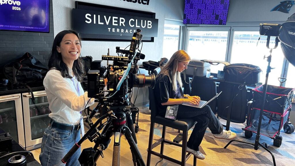 Camerawoman from Final Cut Multimedia operating camera on set in the Silver Club Terrace at Carolina Panthers Stadium.